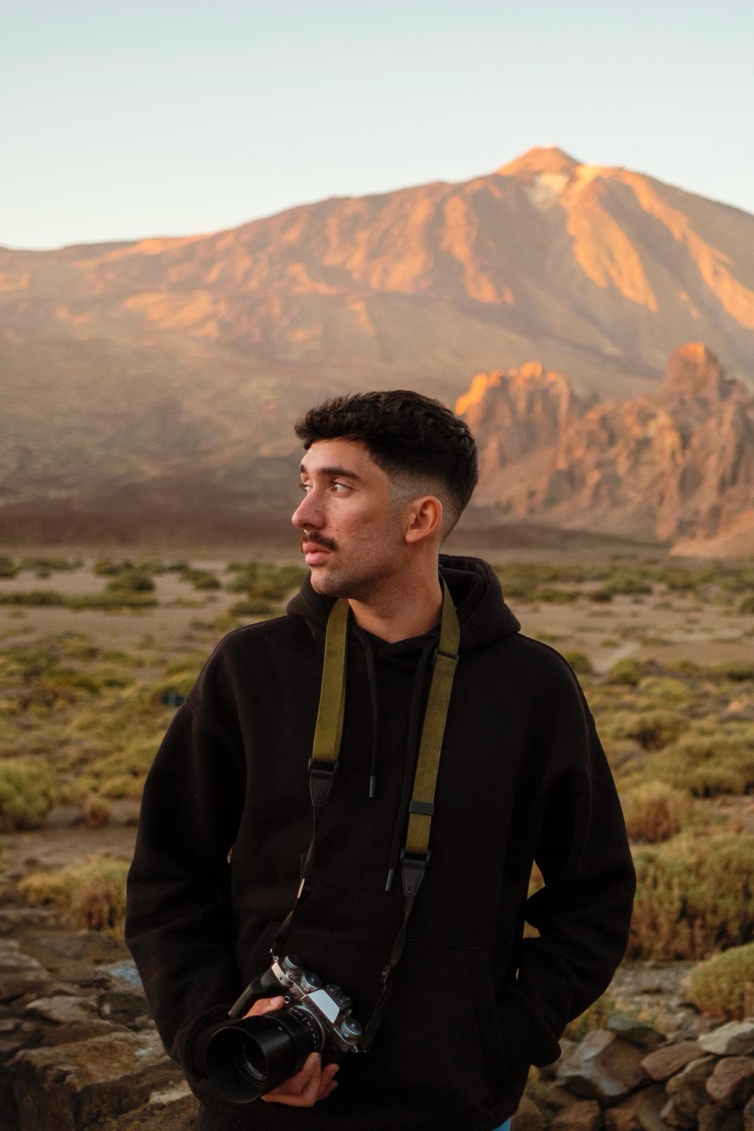 Suso Garcia holding a camera in a mountain landscape