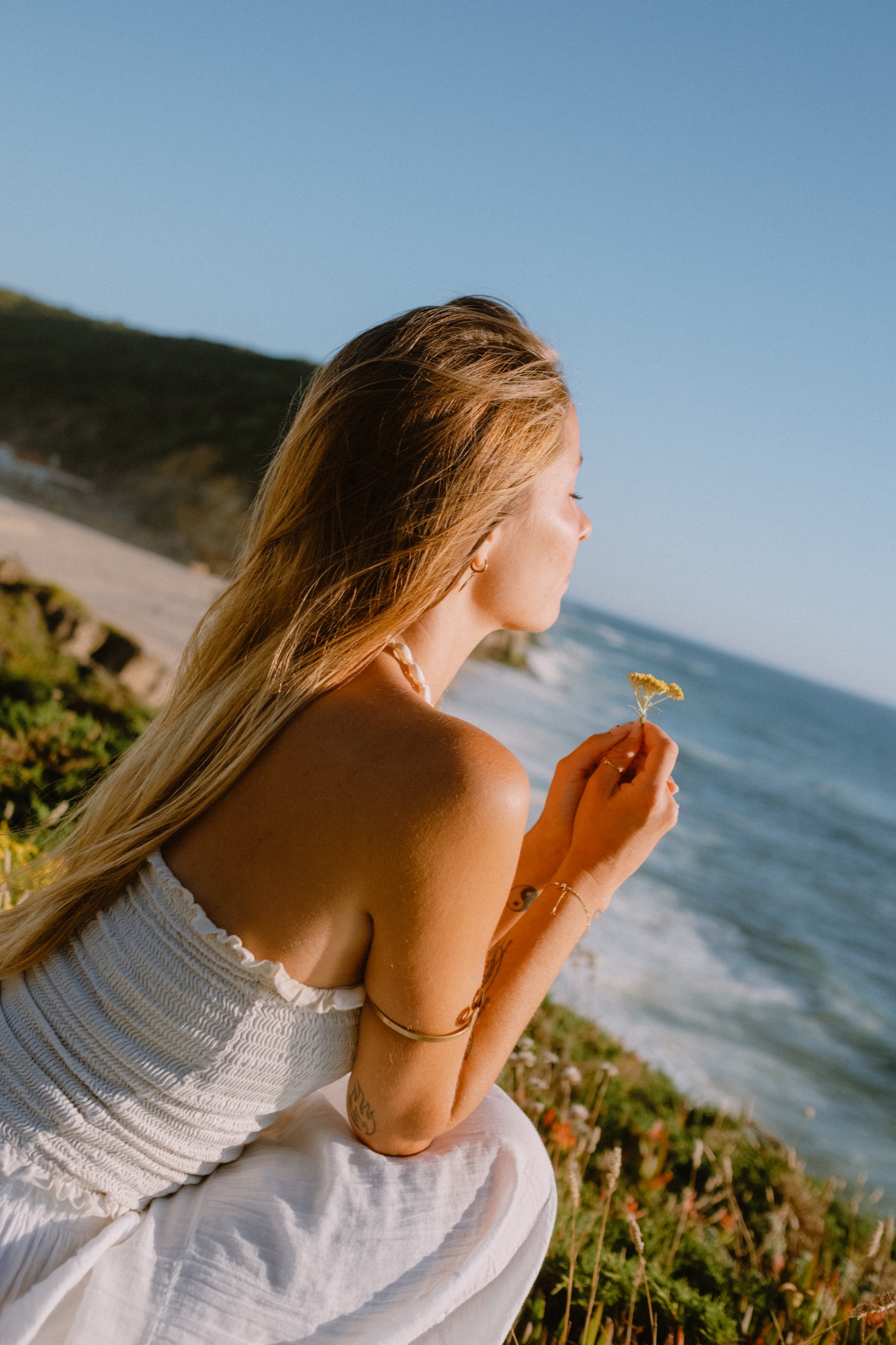 Amelia holding a flower above the Atlantic