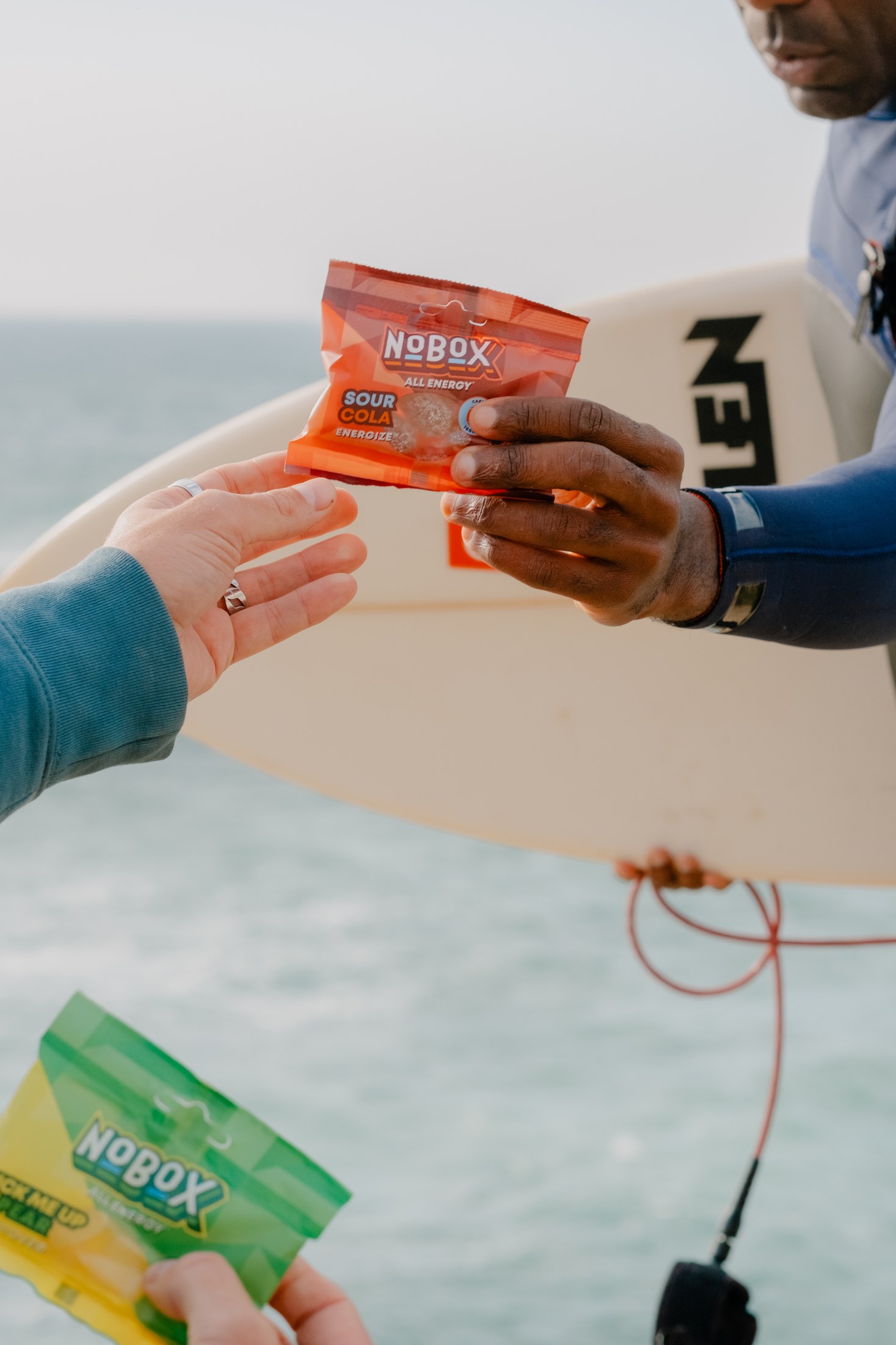 Sharing NoBox beside a surfboard