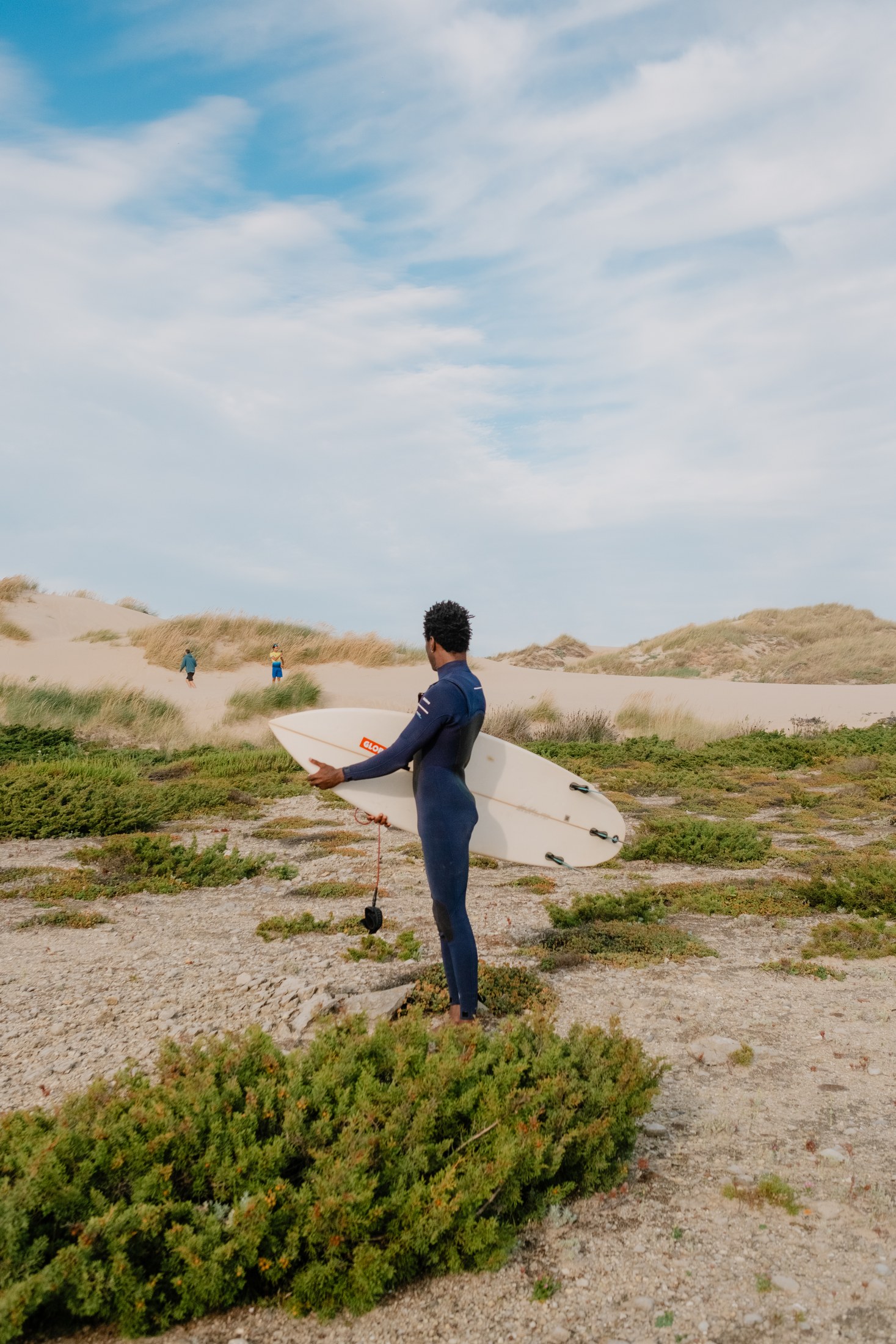 Walking through the dunes with a board
