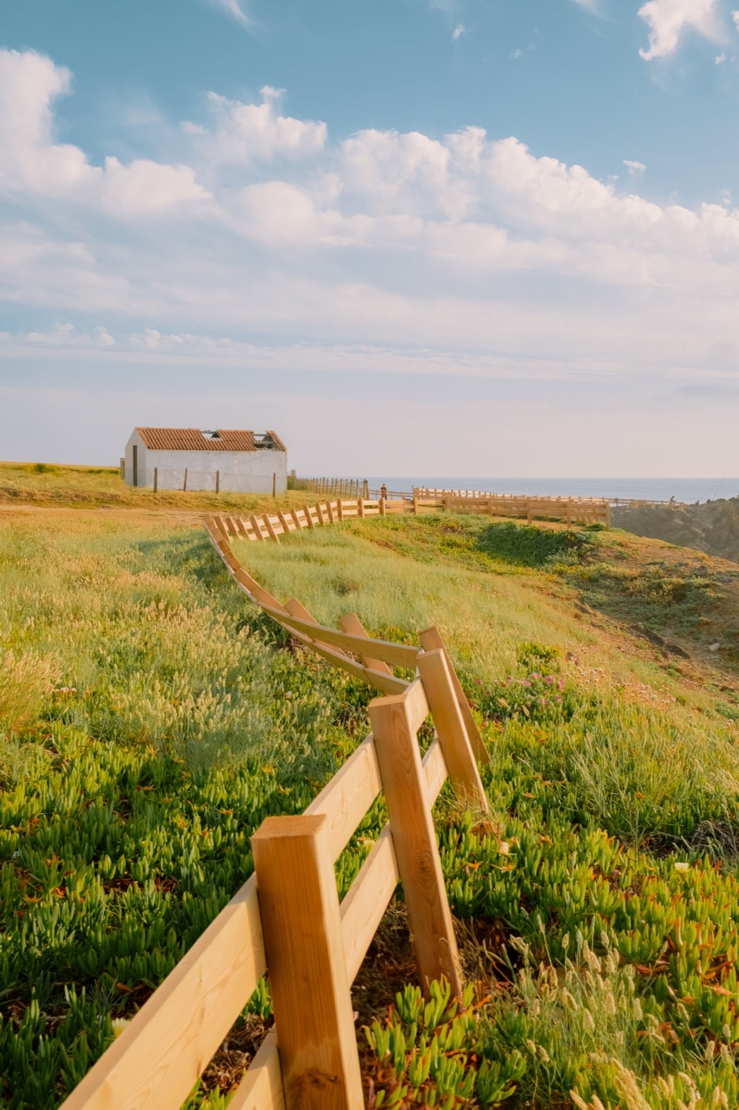 Coastal landscape with wooden fence and white house