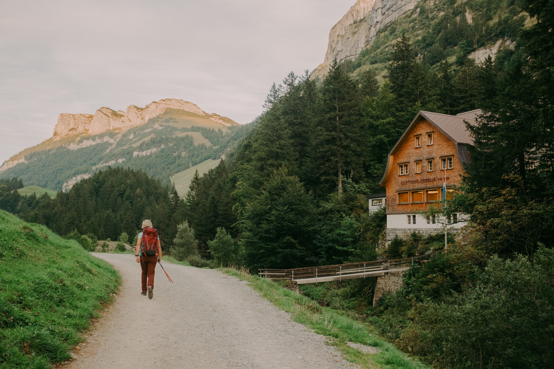 Hiker approaching a mountain lodge through the forest