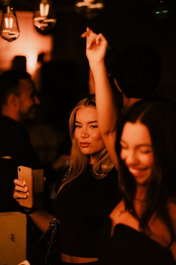 Woman dancing beneath warm night lights