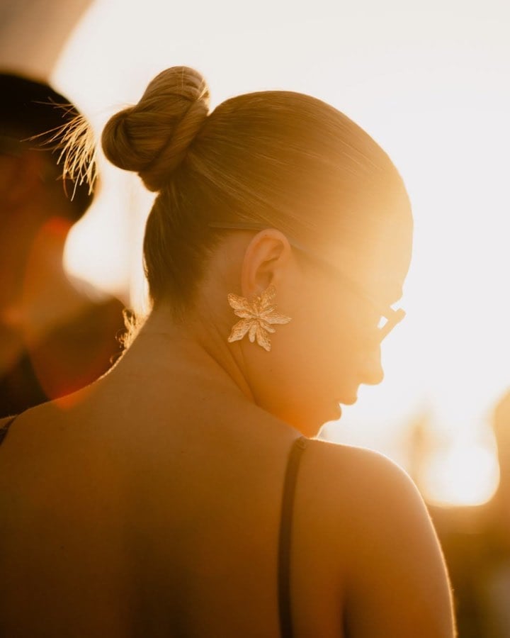 Woman in warm backlight wearing a flower earring