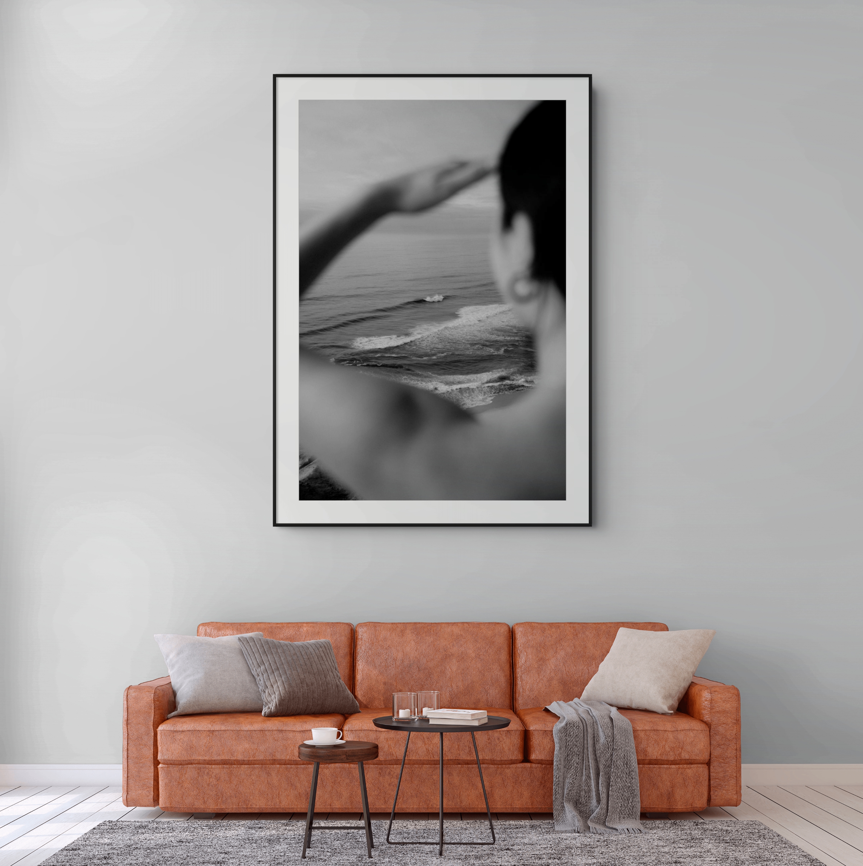Black and white coastal print displayed above a leather sofa